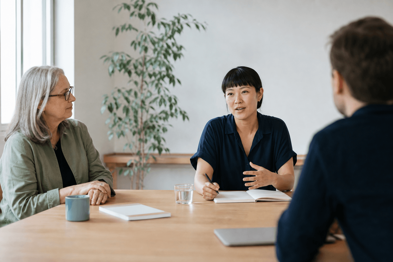 A senior leader listens as an emerging leader guides a small nonprofit meeting.